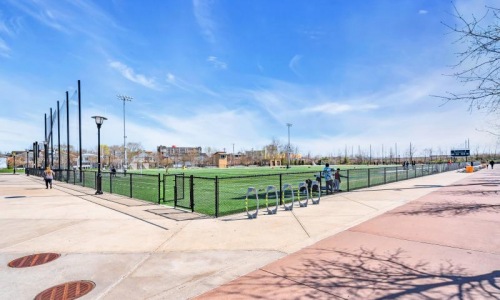 gated sports field surrounded by wide sidewalks